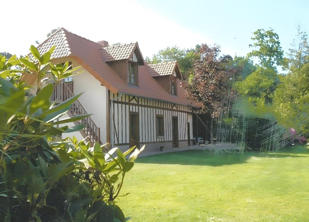 a house with a green yard with a fence at Sous Les Bruyères in Sainte-Marguerite