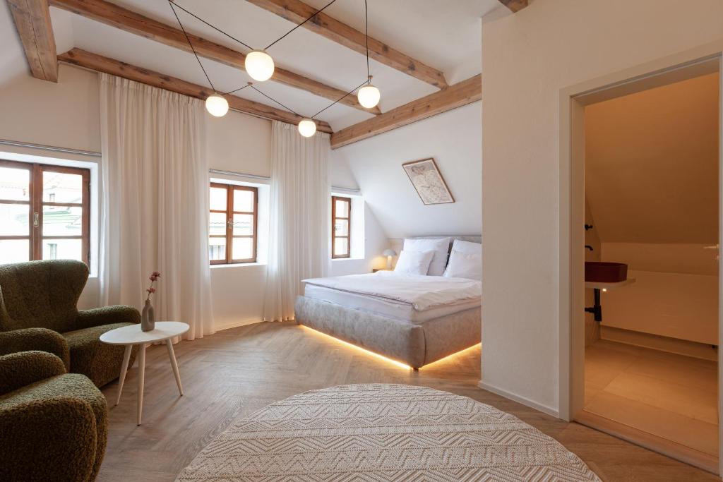 a bedroom with a bed and a couch and a chair at Pension Marie in Český Krumlov