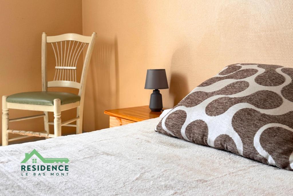 a bedroom with a chair and a bed with a pillow at Résidence du Bas Mont in Moulay