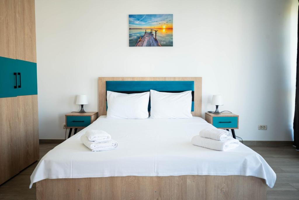 a bedroom with a large white bed with two night stands at Kazeboo Bed & Breakfast in Mamaia Sat/Năvodari