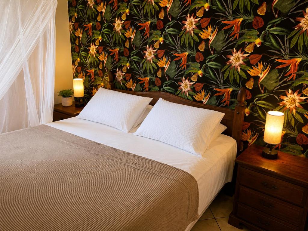 a bedroom with a large bed with a floral wallpaper at Rancho el Sobrino in Sabana Westpunt