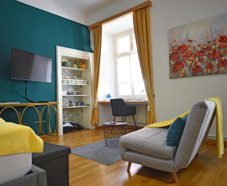 a living room with a couch and a chair at Studio MAYA in Maribor