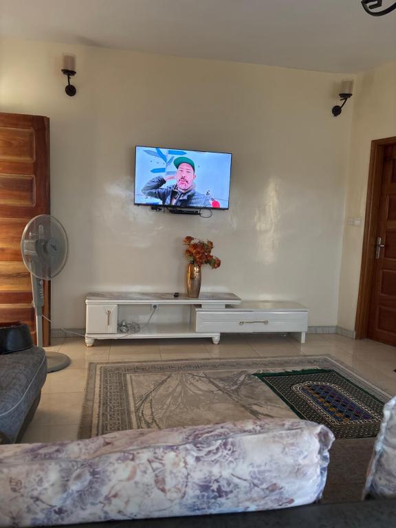 a living room with a flat screen tv on the wall at Super appartement in Thiès