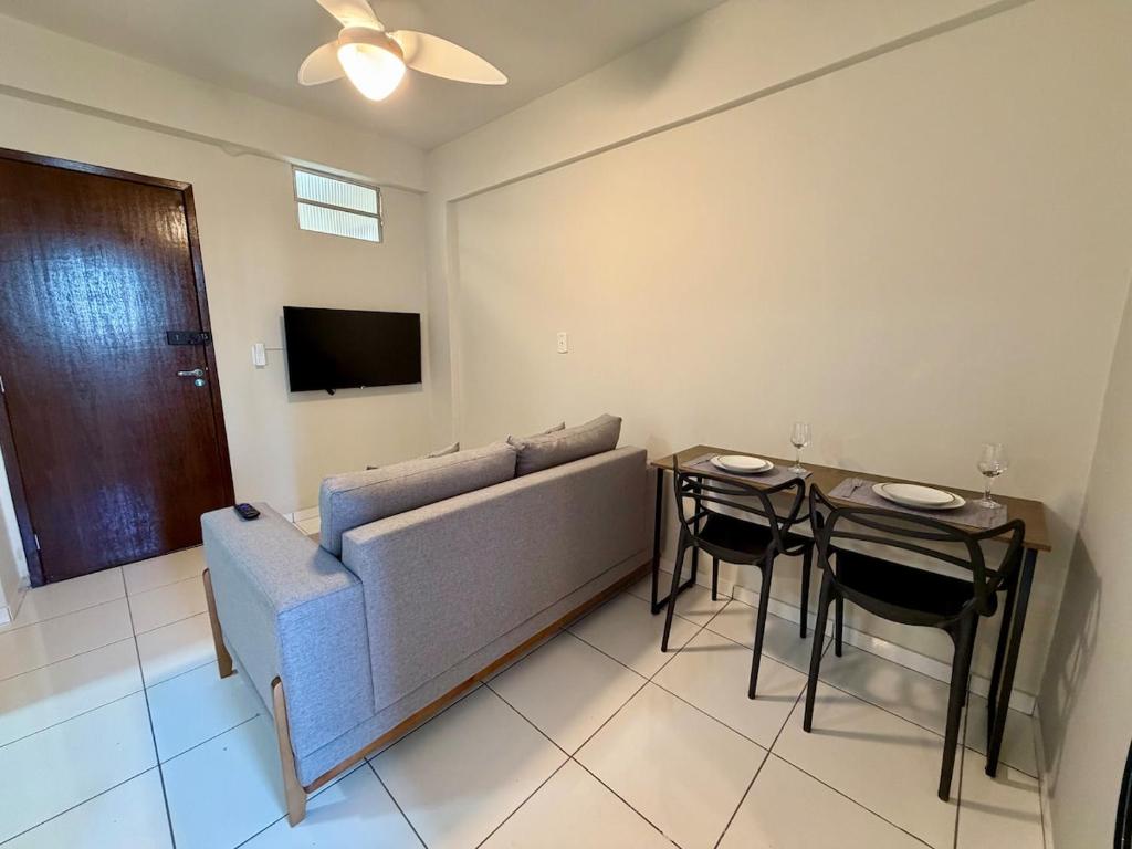 a living room with a couch and a table with chairs at Apto com 2 quartos e A/C no Centro e Santa Casa in Montes Claros