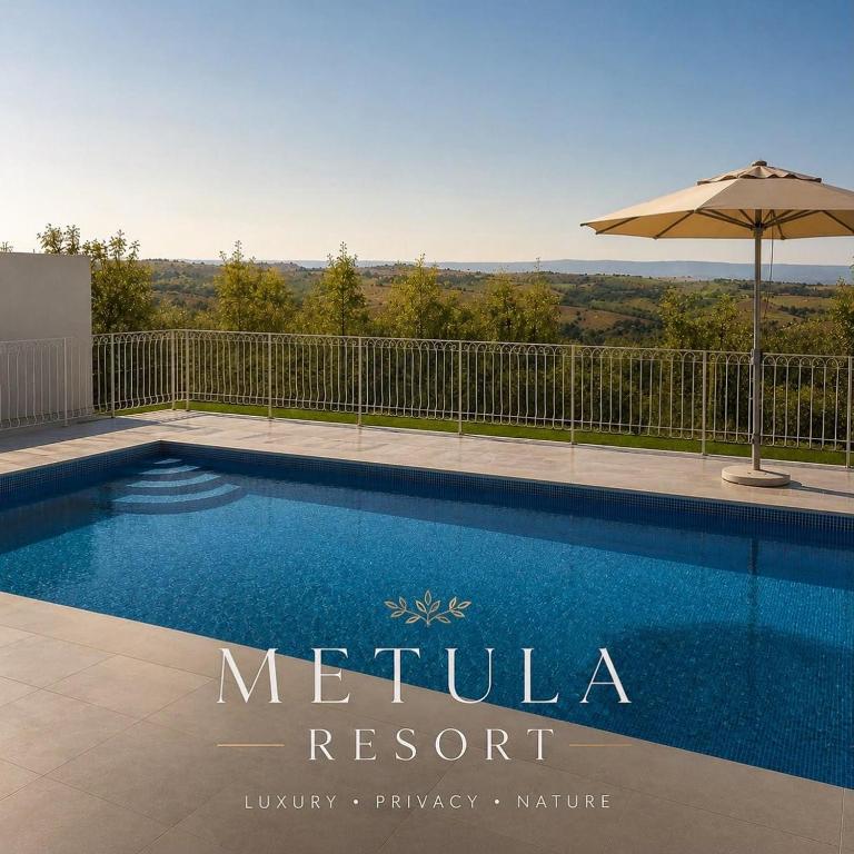 a swimming pool with an umbrella next to a fence at שושנת מטולה in Metulla