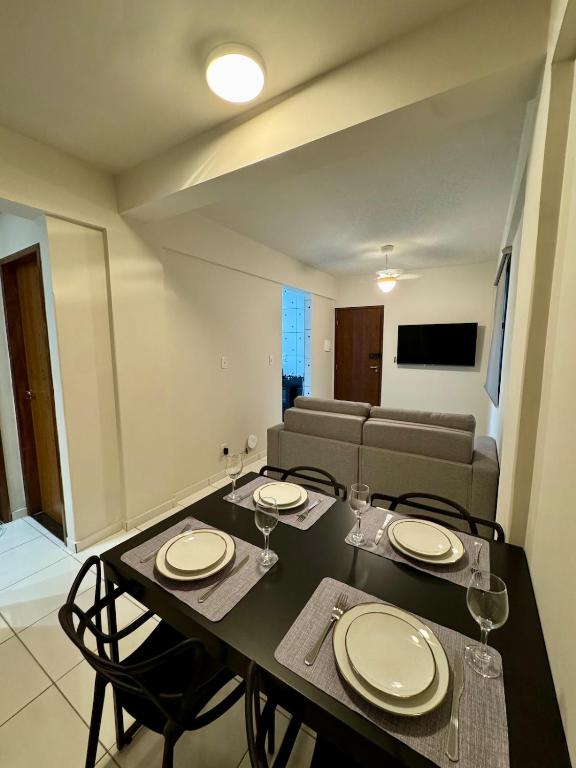 a dining room with a table and chairs and a couch at Apto com 2 quartos e A/C no Centro in Montes Claros