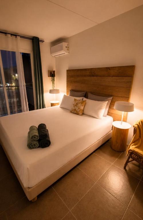 a bedroom with a large white bed with two bags on it at Studio LY'S in Saint-François
