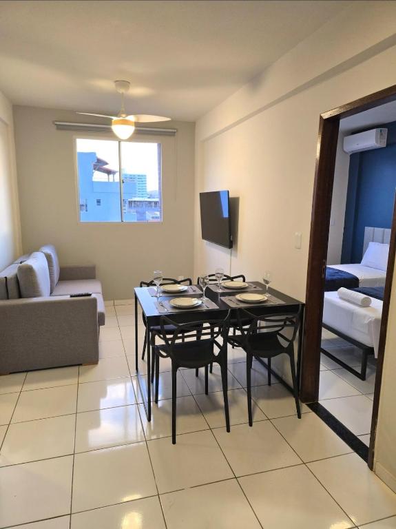a living room with a table and chairs and a couch at Apto com 2 quartos e A/C no Centro in Montes Claros