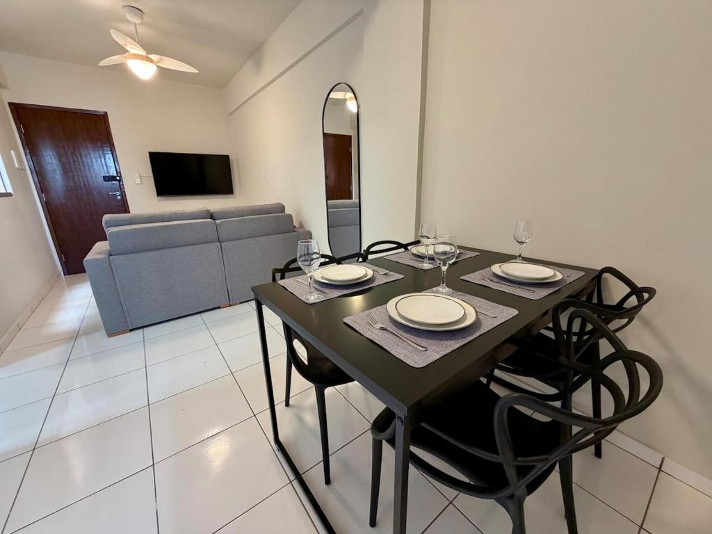 a dining room with a table and chairs and a couch at Apto com 2 quartos e A/C no Centro in Montes Claros