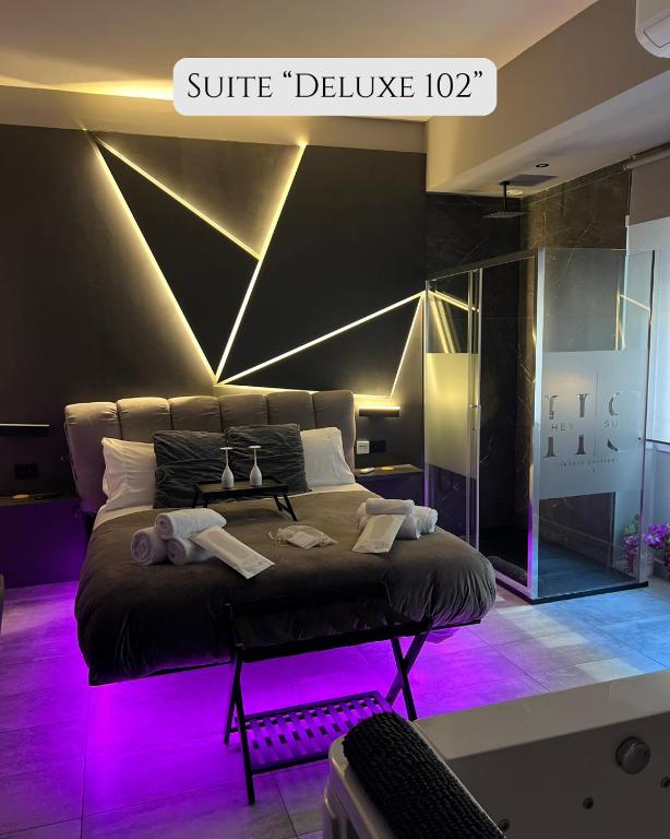 a bedroom with a large bed with purple lighting at HeySuite Trastevere GuestHouse ROMA in Rome