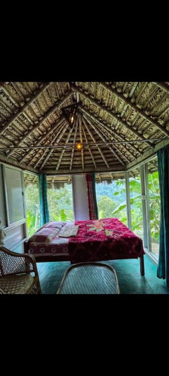 a bedroom with a bed under a large umbrella at The Cloud door in Perumālmalai