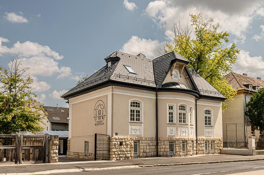 a house with a black roof on a street at Nádor Rezidencia in Győr