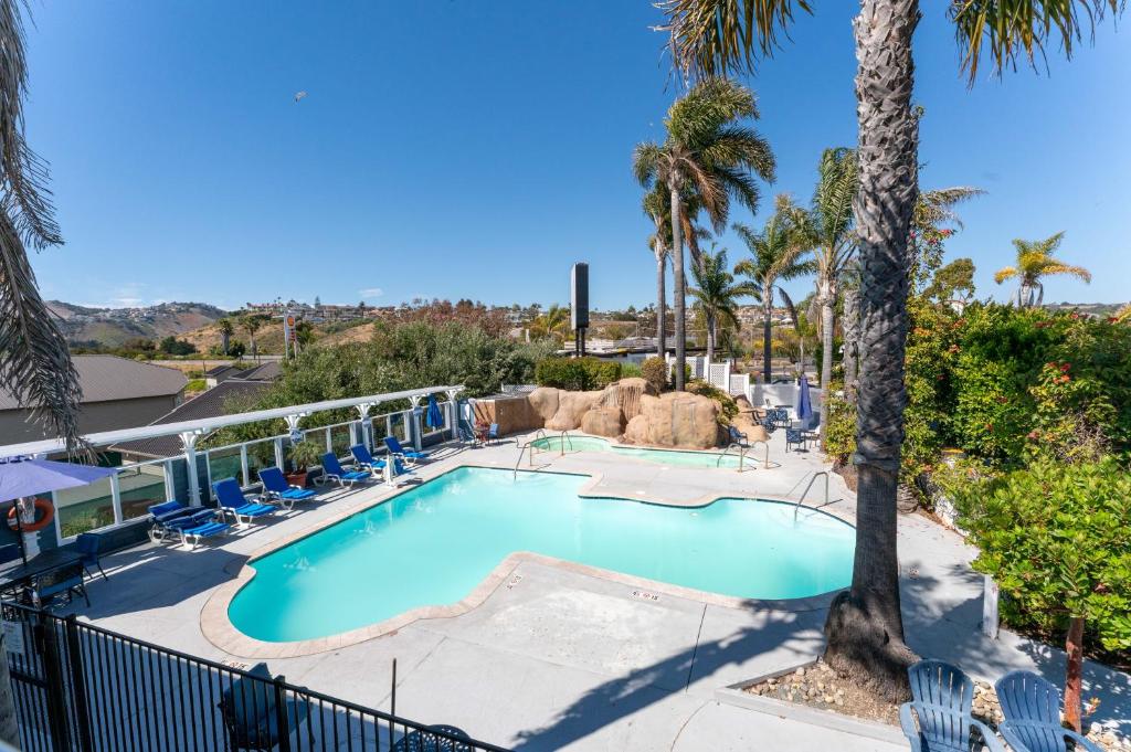 a swimming pool with chairs and a resort at The Grove at Pismo Beach in Pismo Beach