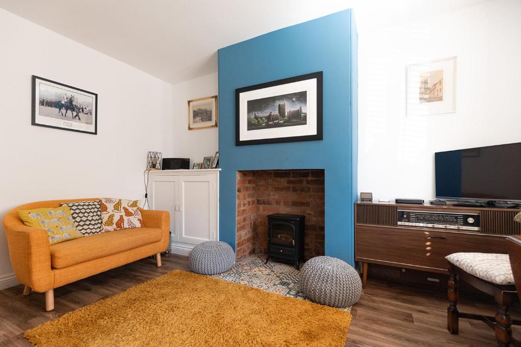 a living room with a blue accent wall at JACKS COTTAGE - Cosy Cottage in the Heart of Richmond in Richmond