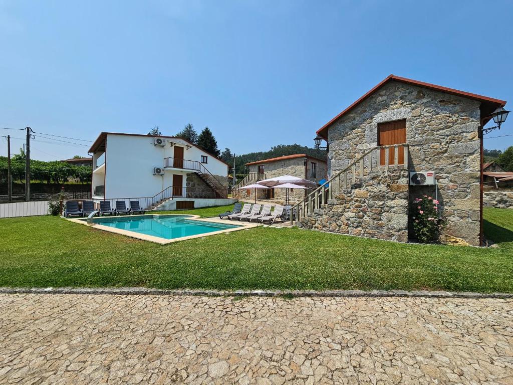 a villa with a swimming pool and a house at Quinta da Cachada in Lousada
