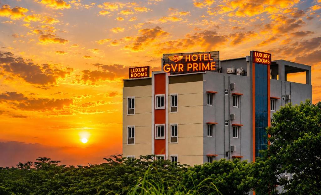 a hotel with a sign on top of it at sunset at Hotel GVR Prime in Guntūr