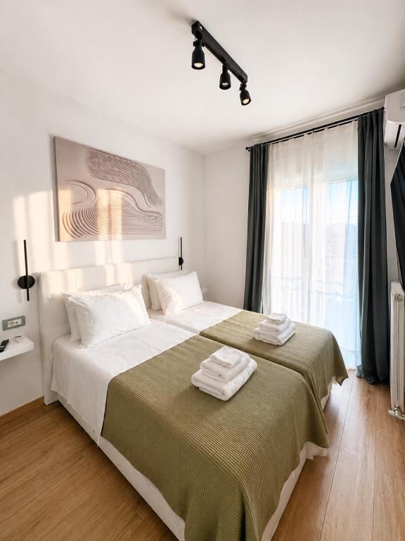 a bedroom with a large bed with towels on it at Zen Stay Maisonette in Igoumenitsa