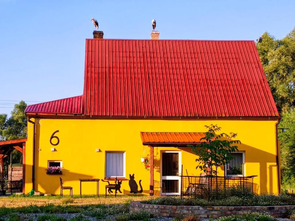 a yellow house with a red roof at Haus 6 am Fluß in Witnica