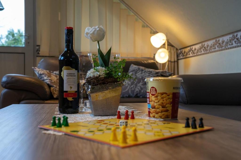 a bottle of wine and a chess board on a table at Ferienwohnung STEUERMANN in Werdum in Werdum