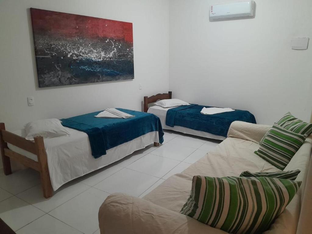 a living room with two beds and a couch at Casa Verde in Morro de São Paulo