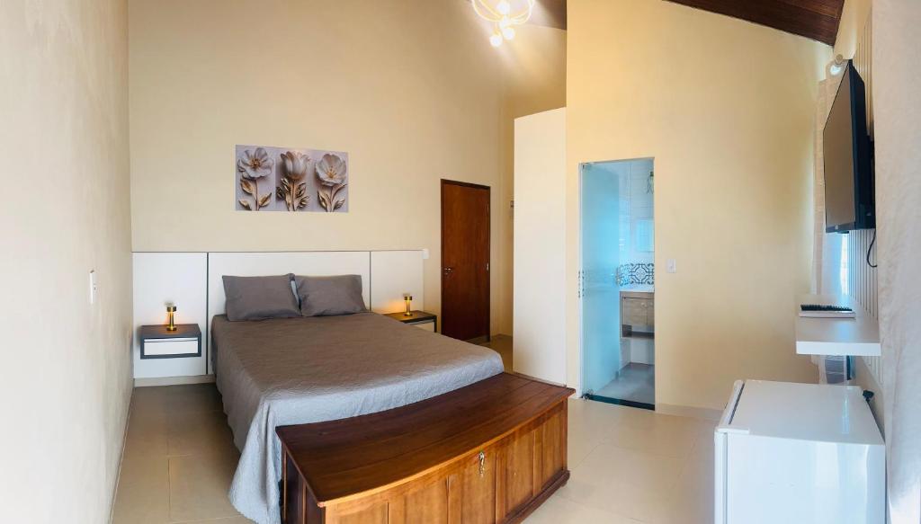 a bedroom with a bed and a television in it at Suíte Excellence - 02 in Pirenópolis