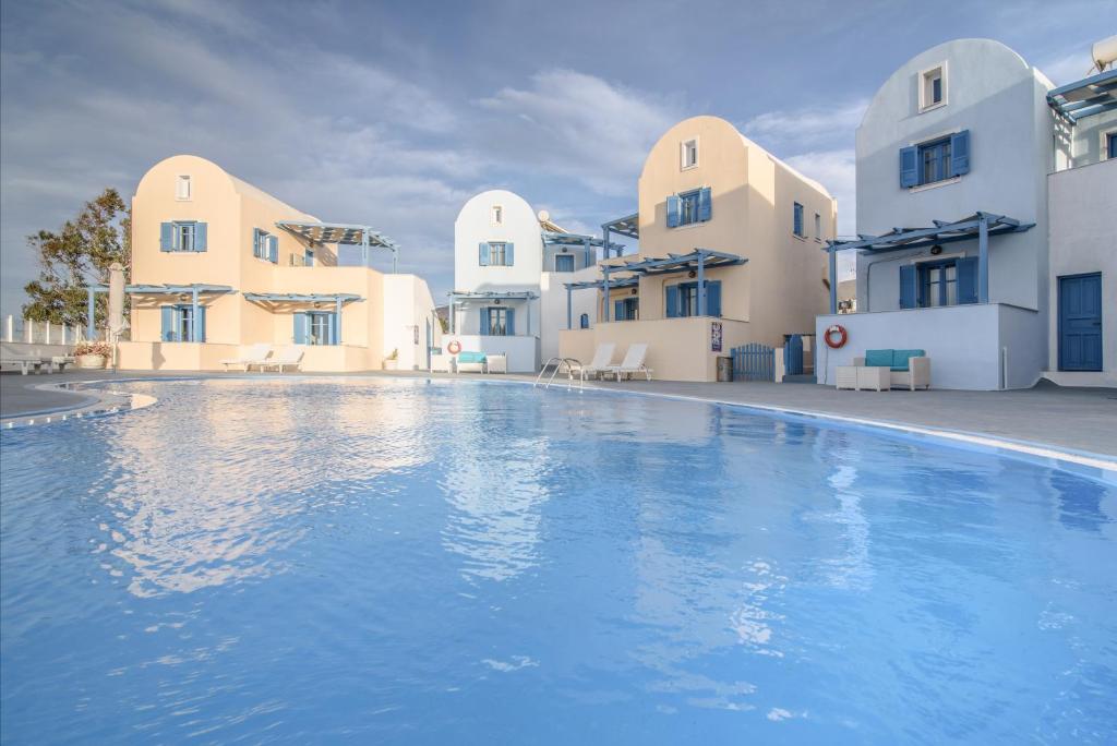 a large swimming pool in front of some buildings at Maria's Place - Adults Only in Oia
