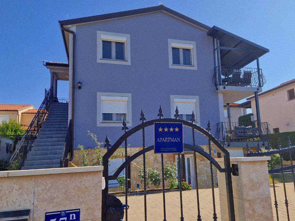a blue house with a gate in front of it at Apartment Vanessa in Murine