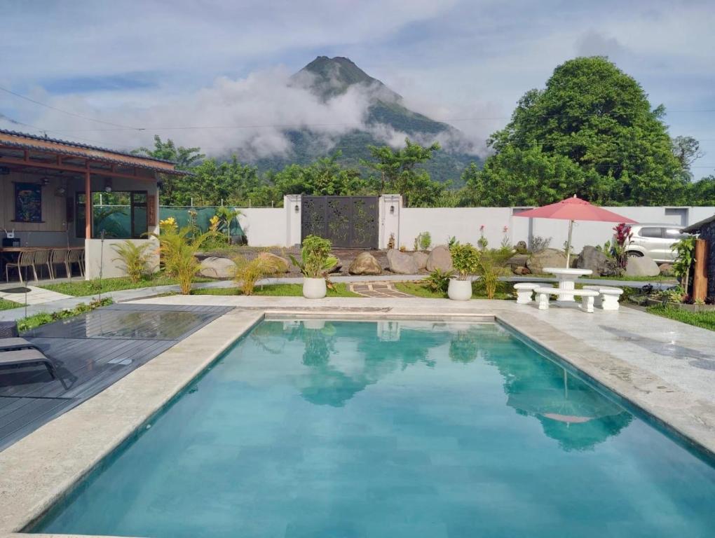 a swimming pool with a mountain in the background at Kokoro Garden in Fortuna