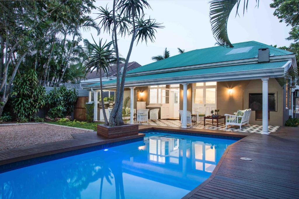 uma casa com piscina em frente a uma casa em Madeline Grove Bed & Breakfast em Durban