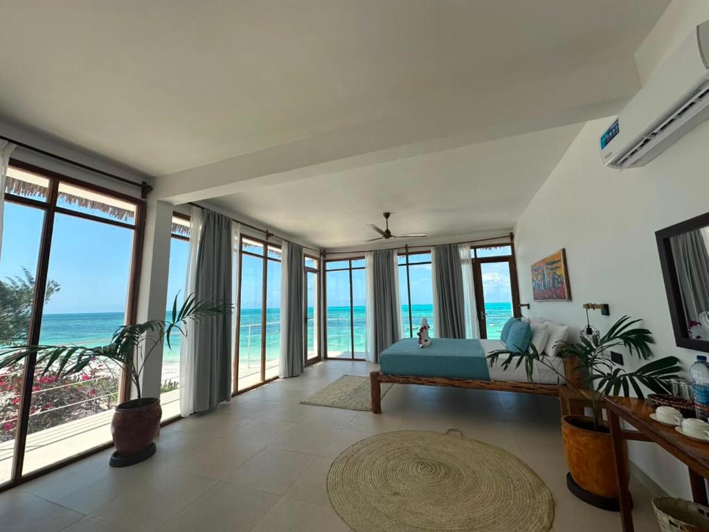 a bedroom with a bed with a view of the ocean at Belvedere Resort in Jambiani