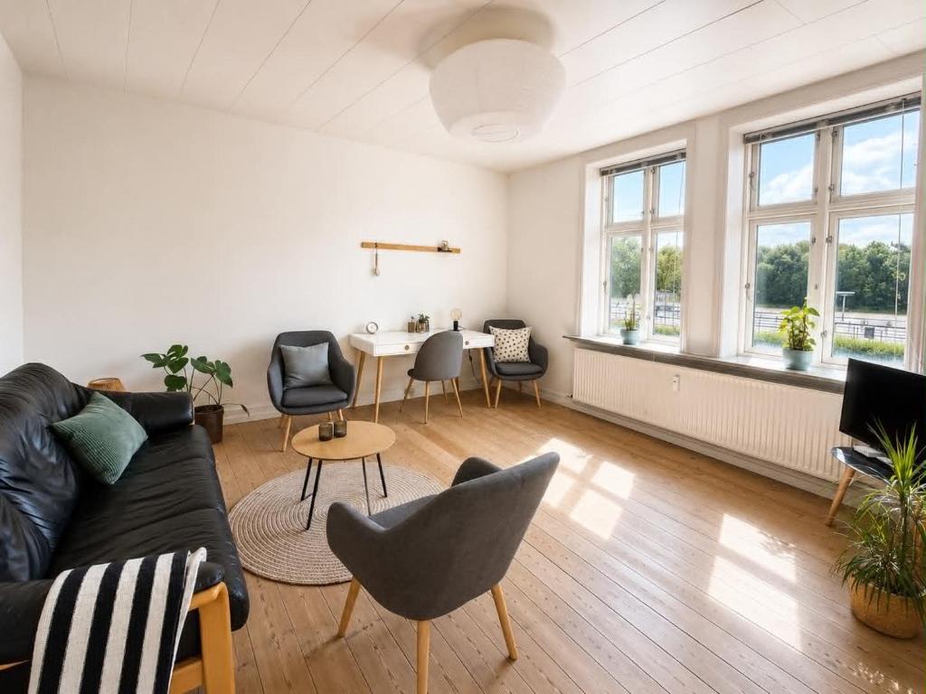 a living room with a couch and chairs and a table at Lejlighed midt i Thisted in Thisted