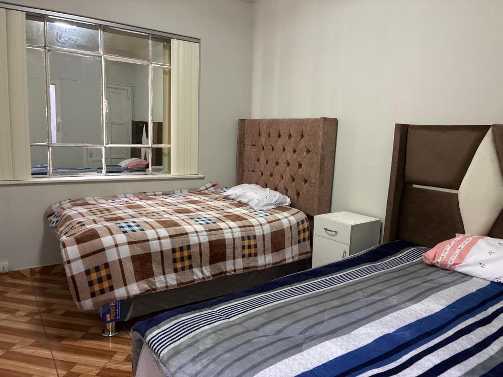 a bedroom with two beds and a window at Nazareth in Lima