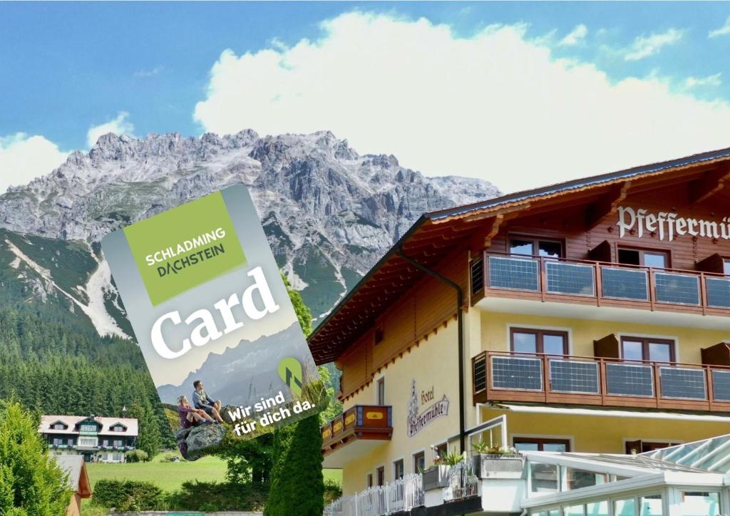 a hotel with a sign in front of a mountain at Aparthotel Pfeffermühle in Ramsau am Dachstein