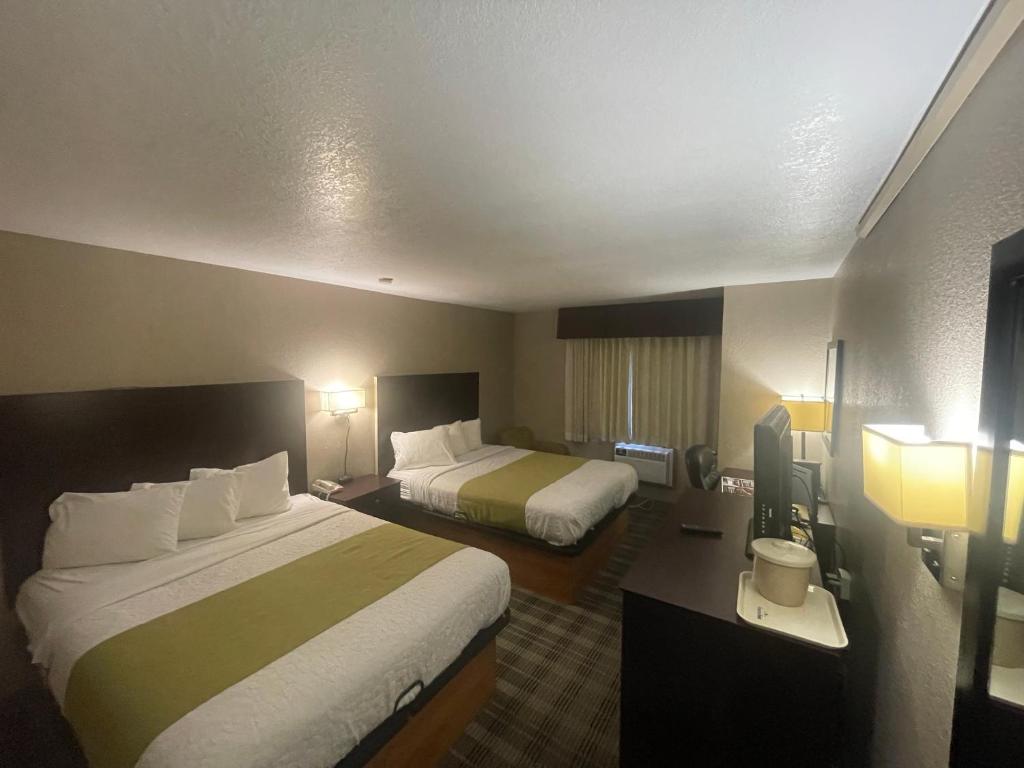 a hotel room with two beds and two lamps at Quality Inn in Council Bluffs