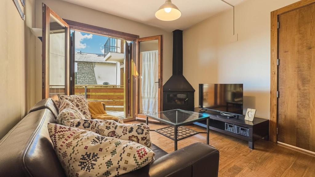a living room with a couch and a tv at Chez Bonheur in Osséja