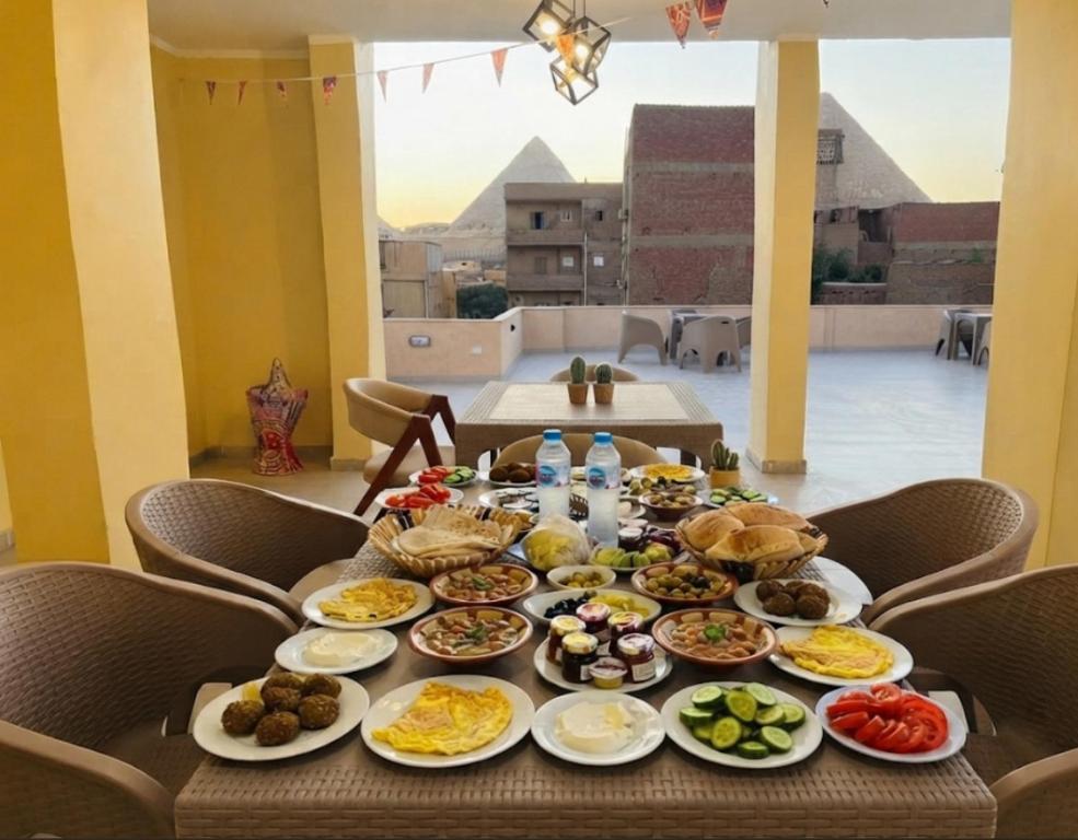 a table full of food on a table with a view at Saloumy pyramids hotel in Nazlat as Sammān