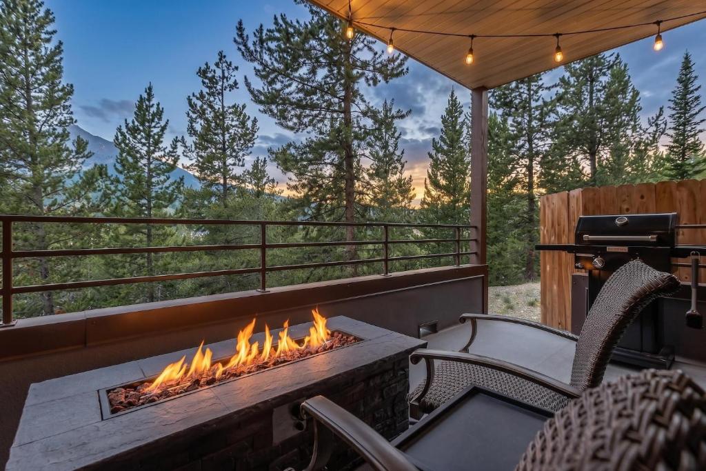 a fire pit on a deck with a grill at Snowflake at Skycrest in Big Sky