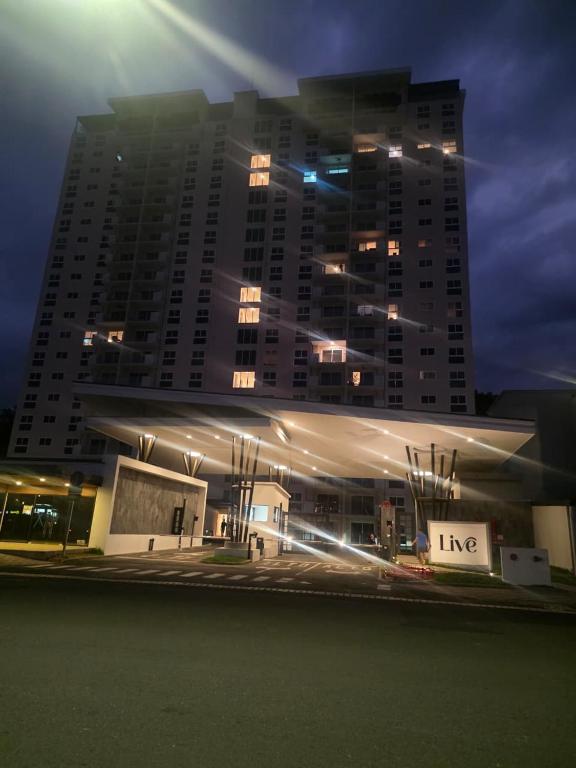 a large building in front of a tall building at night at livejaco405A in Jacó