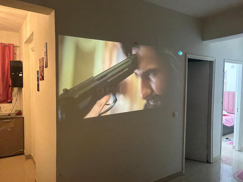 a picture of a man holding a gun on a wall at Cinema Experience -Premium Studio in Karnal