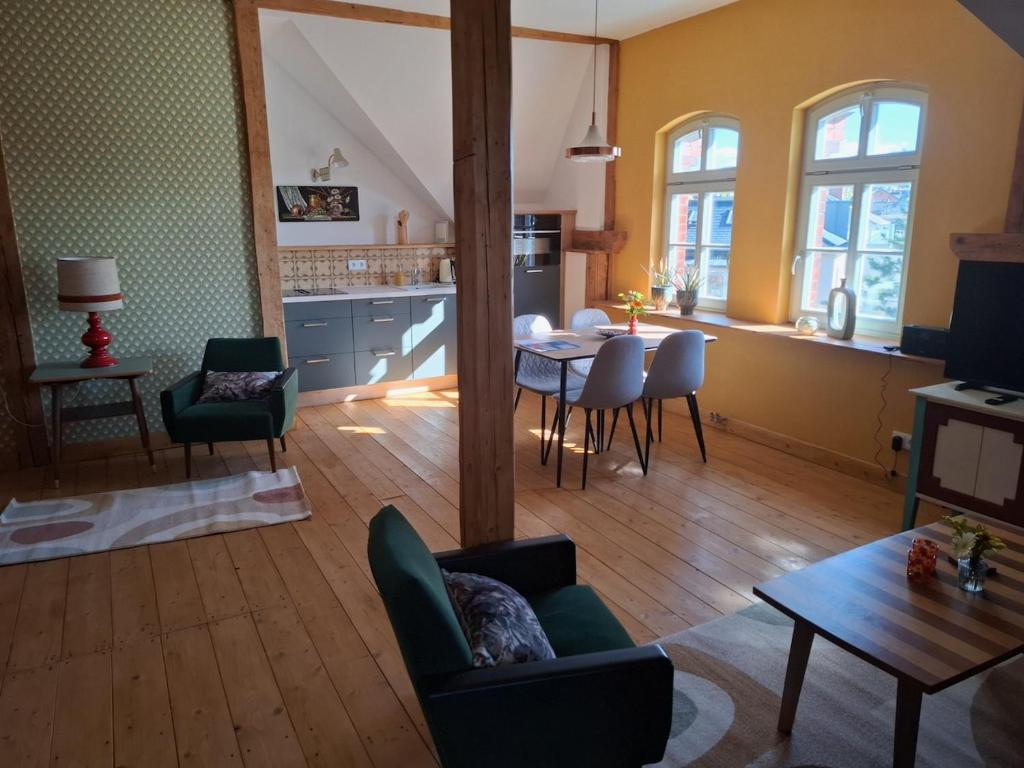 a living room with a table and chairs and a kitchen at Schlossbahnhof Ballenstedt in Ballenstedt