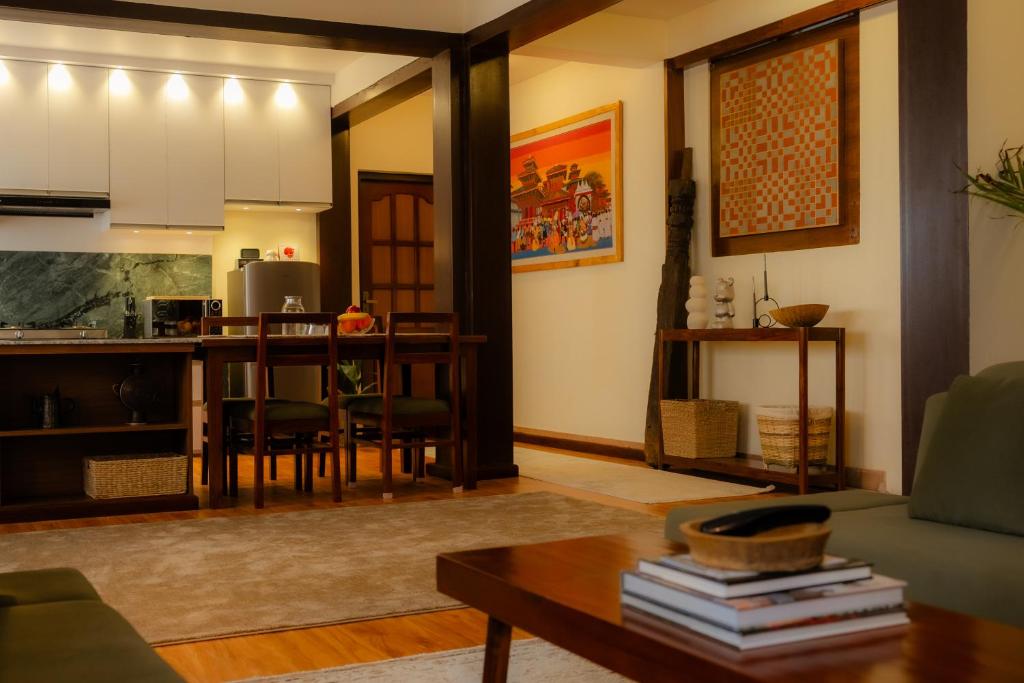 a living room with a table and a kitchen at Gakyi Homes Boudha in Kathmandu