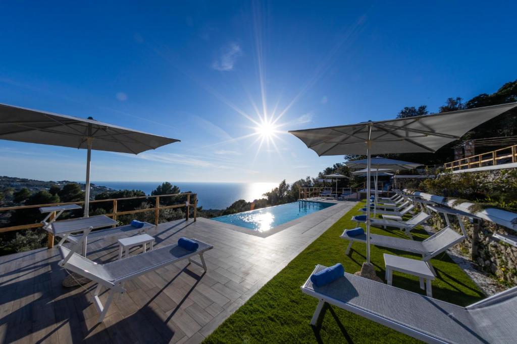 a view of the pool at a resort with chairs and umbrellas at Dimora Maiuri L'Olivella in Anacapri