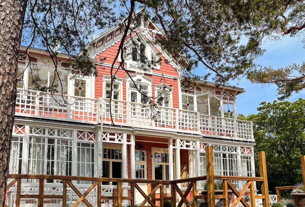 a red and white house with a white balcony at Villa Maija 6 Topside in Hanko