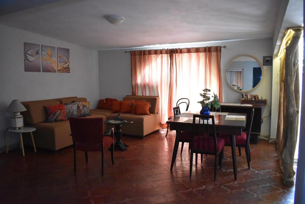 a living room with a couch and a table and chairs at Departamento Loro in Manzanillo