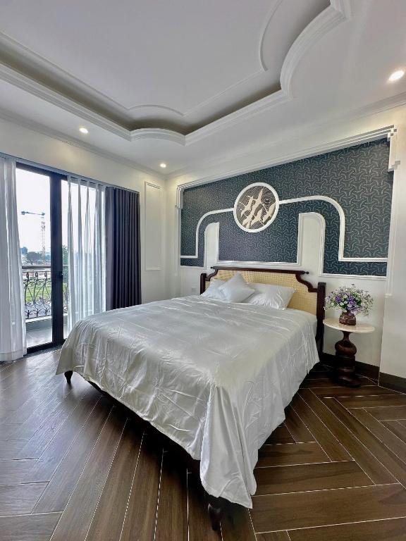 a bedroom with a large bed and a large window at Vững Mạnh Hotel in Ðồng Ky