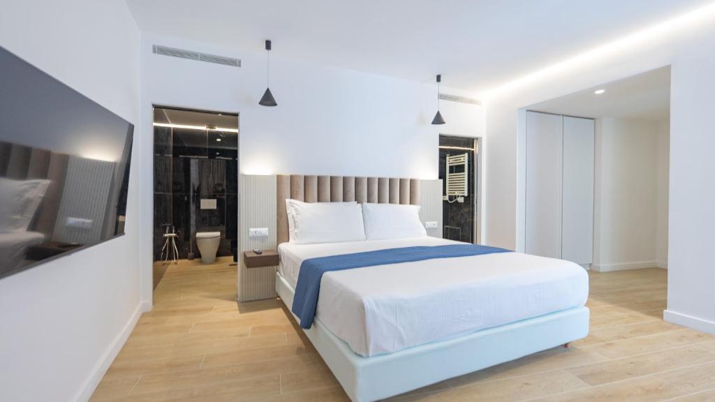 a bedroom with a large white bed and a television at GG Spagna Luxury Suites in Rome