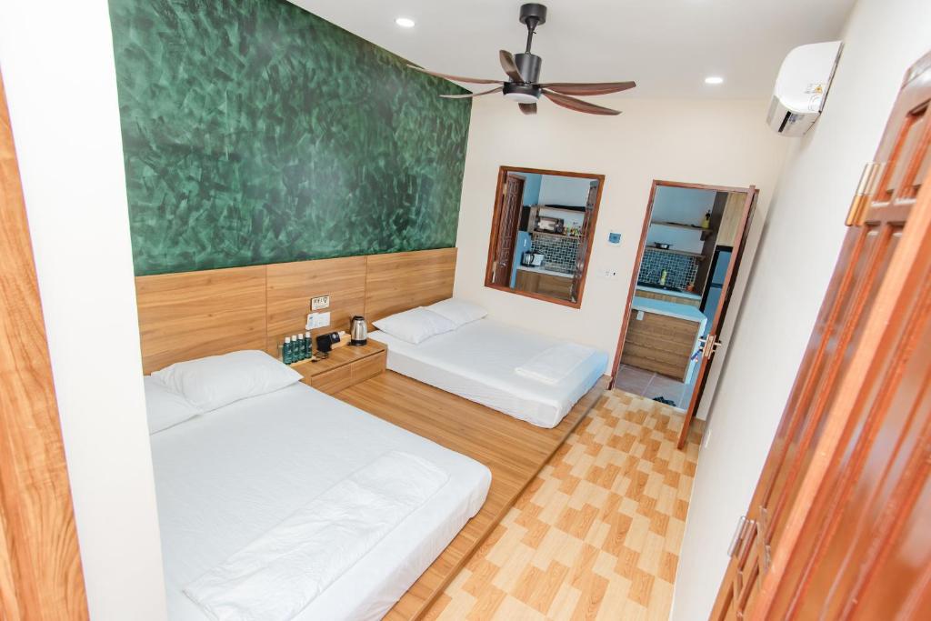a room with two beds and a chalkboard on the wall at 4be Cá Heo in Cầu Sông Kinh