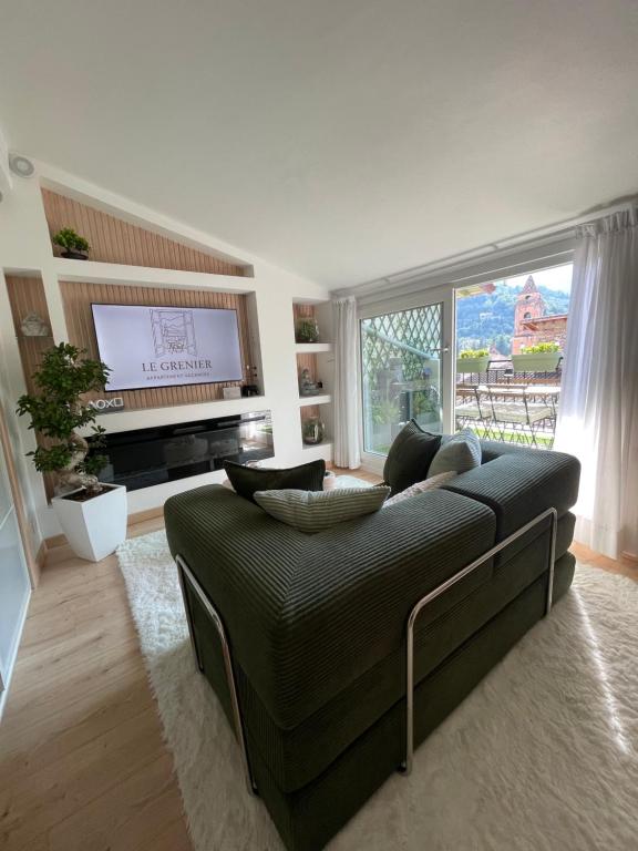 a living room with a couch and a flat screen tv at Le Grenier - Appartement vacances in Breil-sur-Roya