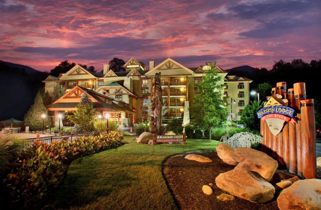 a large apartment building with a teddy bear in the yard at Bearskin Lodge on the River in Gatlinburg