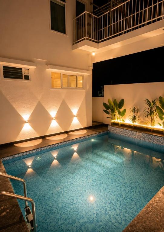 a swimming pool with lights in a building at Luxurious boho pool villa nandi hills in Bangalore